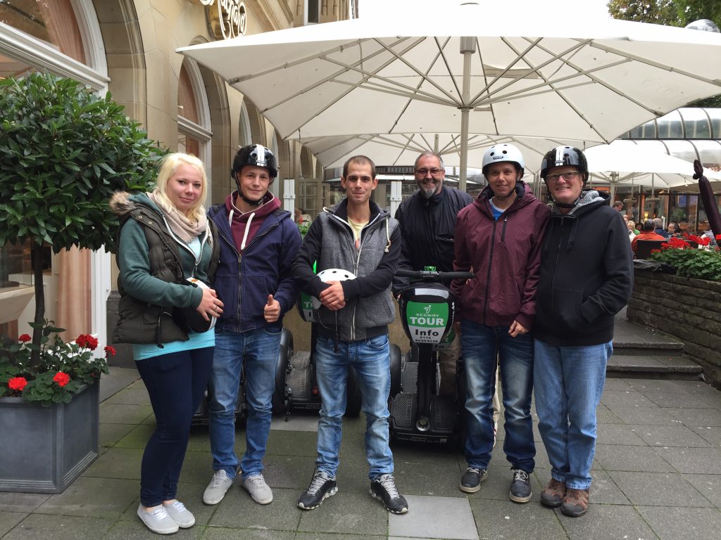 Lachende Gruppe von Teilnehmern einer Segway Tour, alle mit Helmen, ideal für Firmenevents oder einen JGA Köln