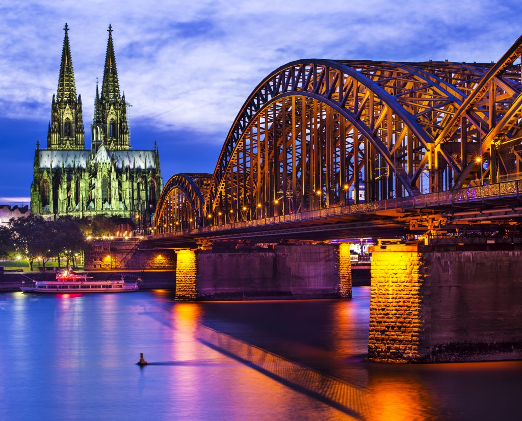 Nachtaufnahme von Köln mit der Hohenzollernbrücke und dem beleuchteten Dom, perfekt für eine Segway Tour Köln